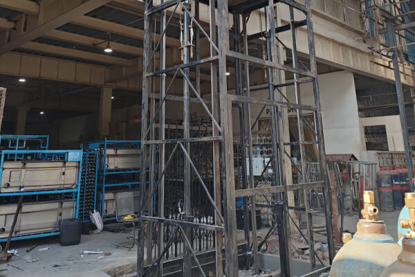 Goods lift mast being installed inside a working plant