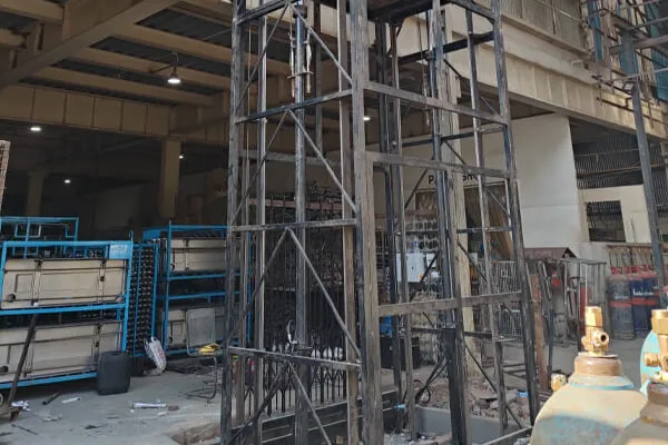 Goods lift mast being installed inside a working plant